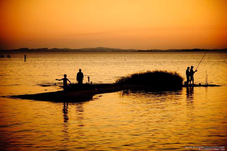beautiful lake landscape with two man fishing during sunset